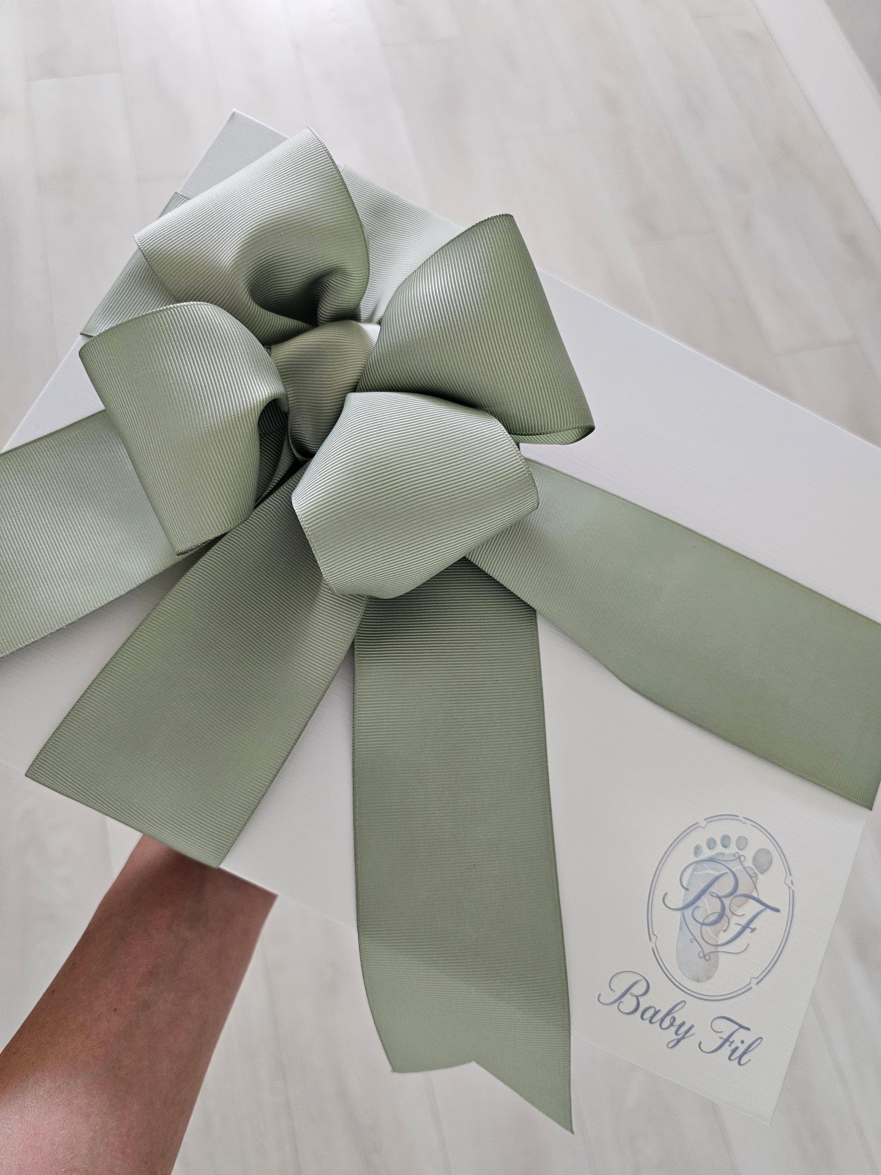 Elegant Baby Fil newborn gift box with a hand-tied sage green ribbon, perfect for baby shower gifts and coming home outfit..