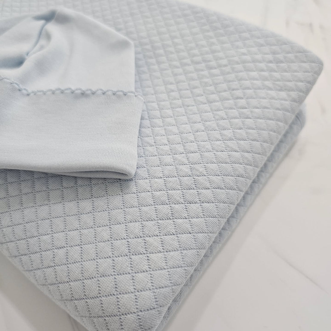 Soft blue Pima cotton newborn baby blanket with classic details, a newborn essential by Baby Fil.